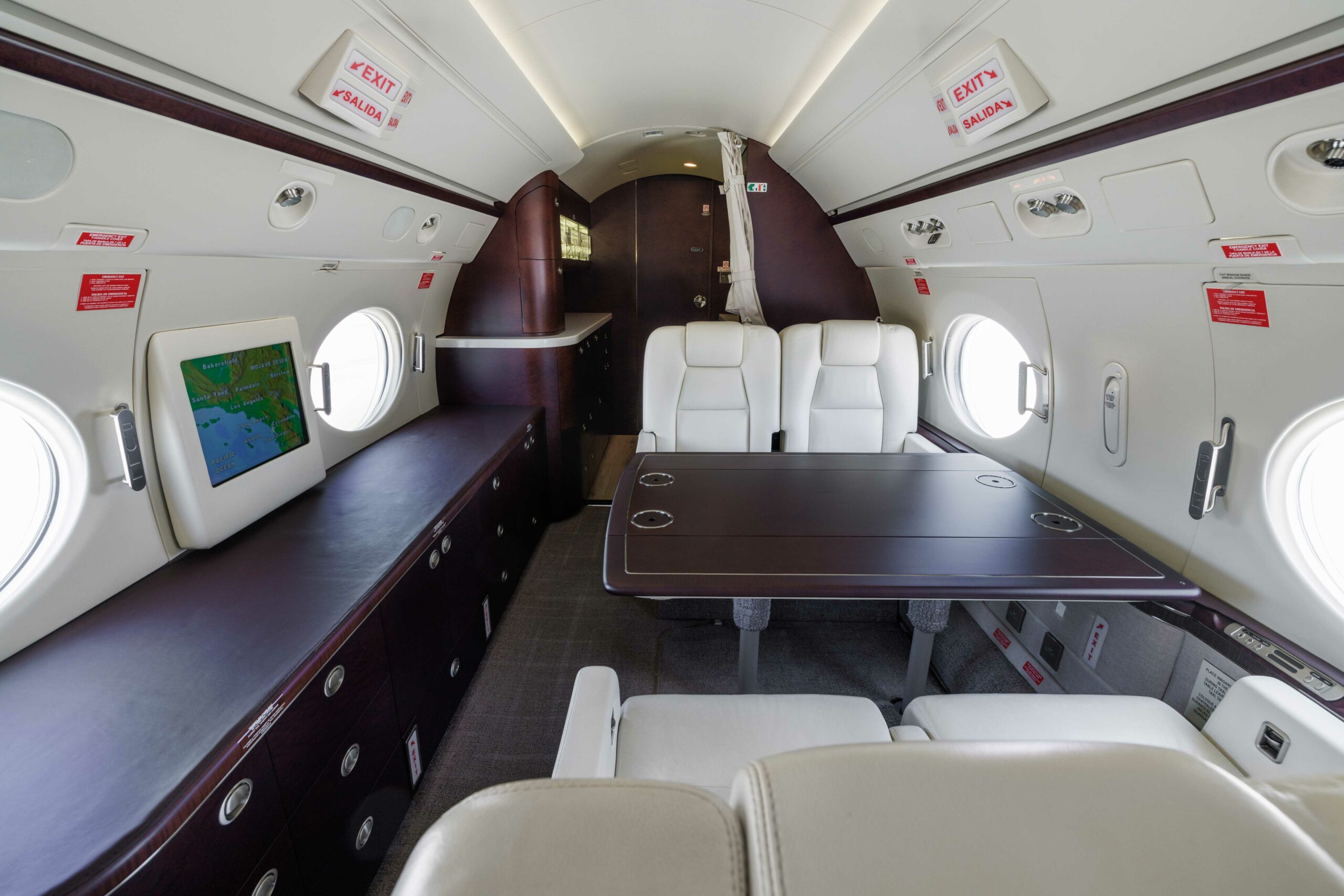 Aft cabin of Gulfstream G550 SN5127 featuring a four-seat conference layout and high-gloss wood finishes
